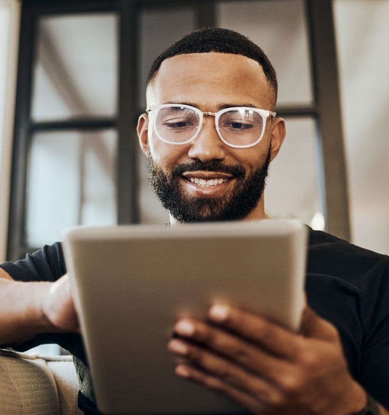 Man wearing glasses looking at a tablet
