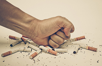 Man crushing cigarettes with fist