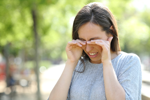 Young woman rubbing her eyes before LASIK