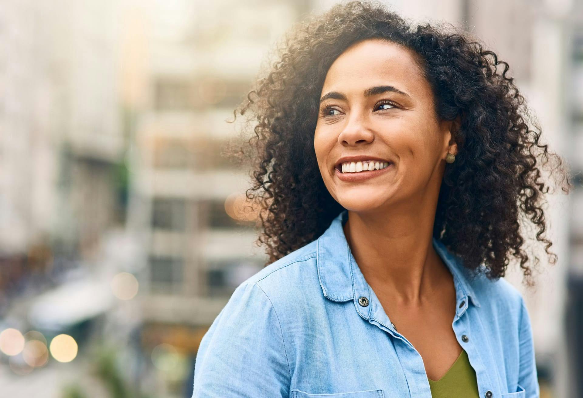 woman with curly hair wearing a blue top