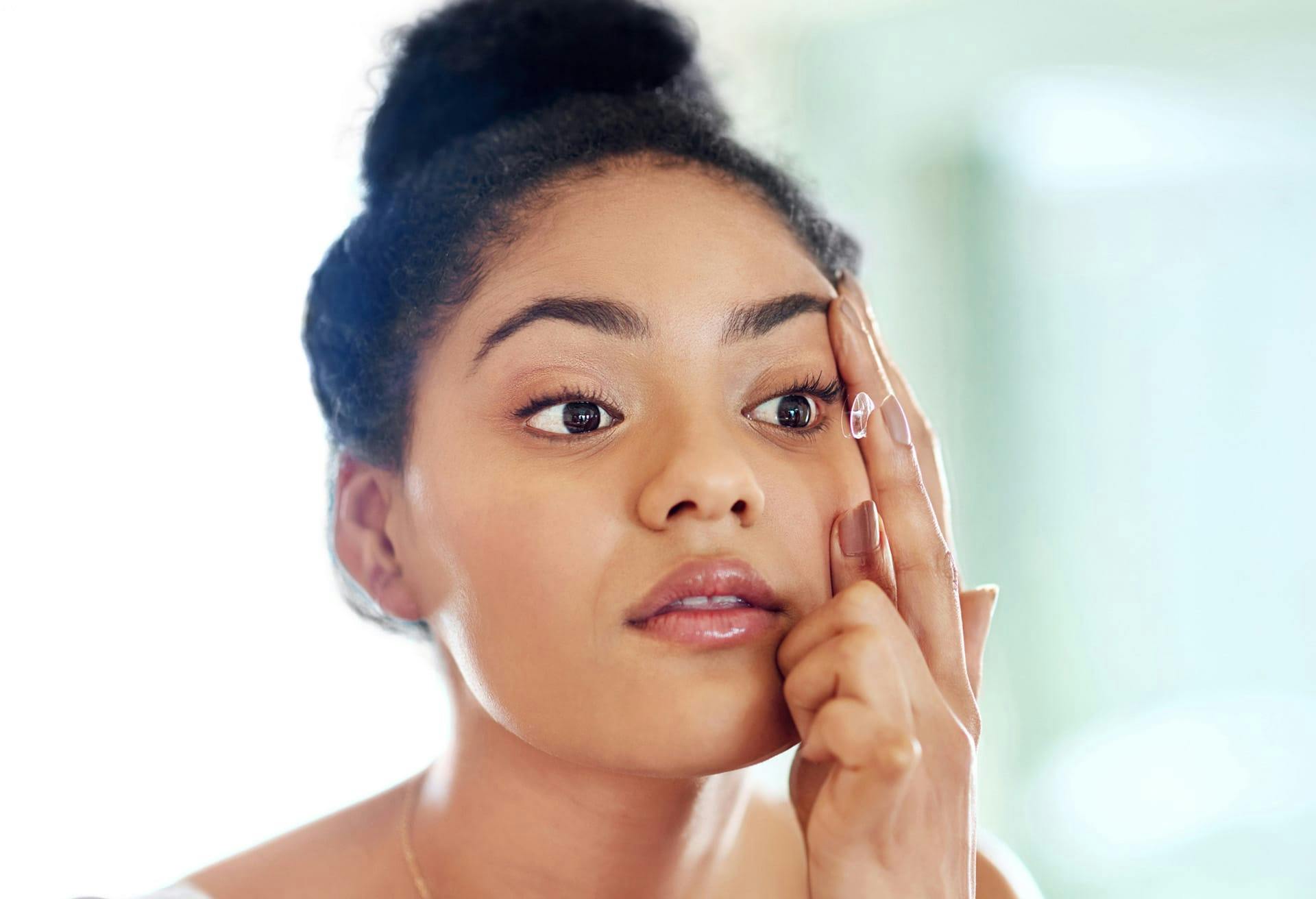 Woman putting in contact lenses