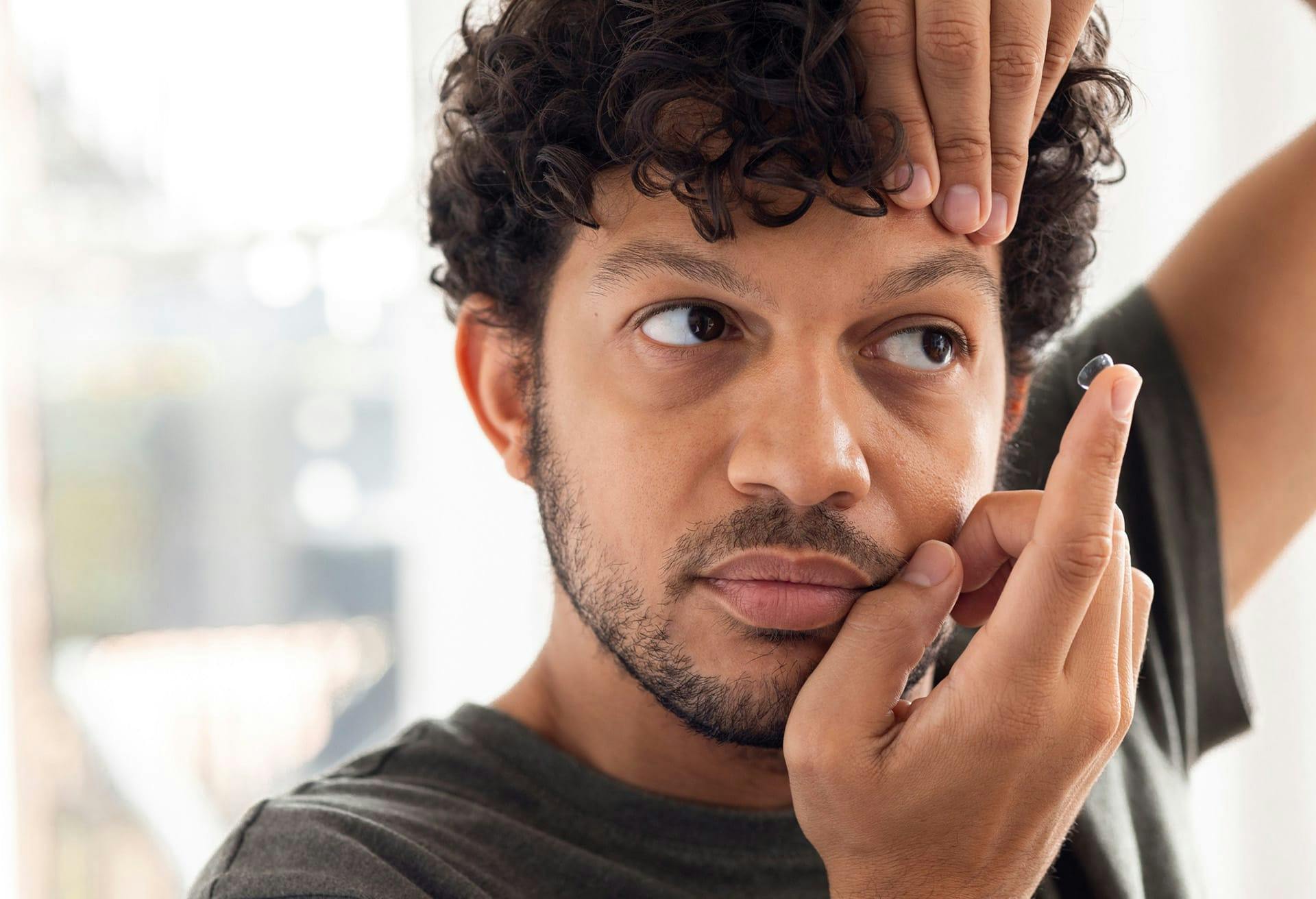 man putting in contact lens