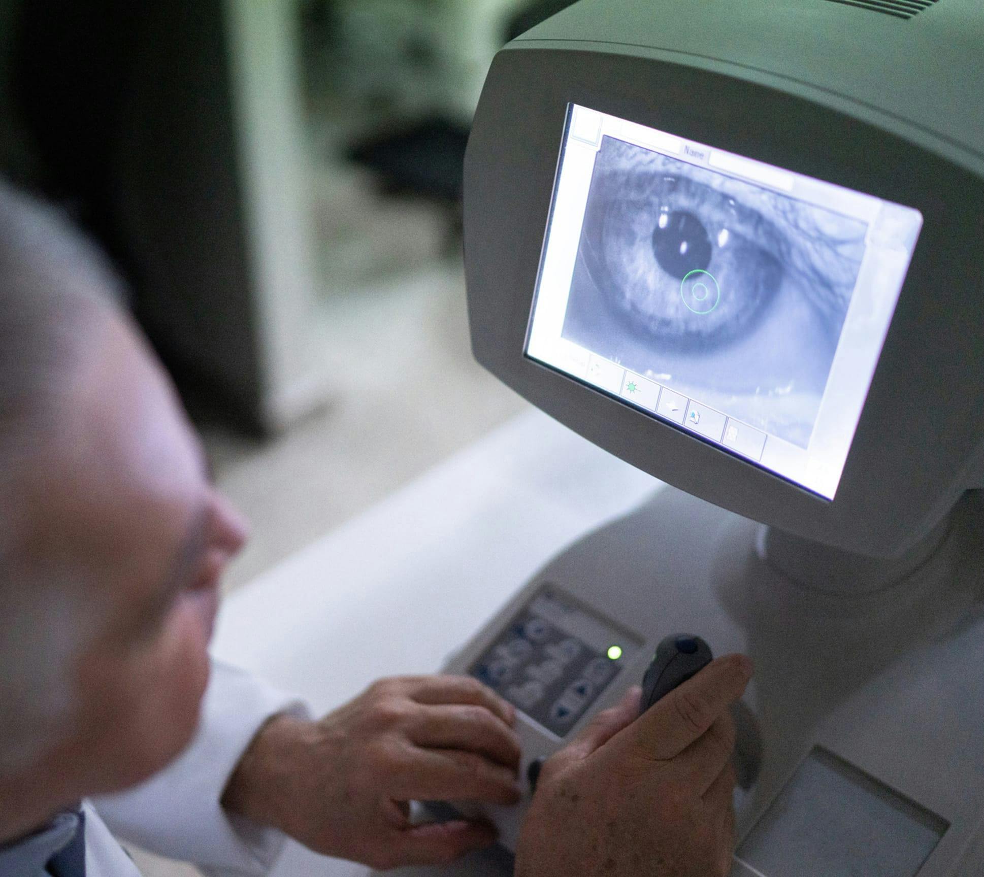 doctor on computer looking at an eye