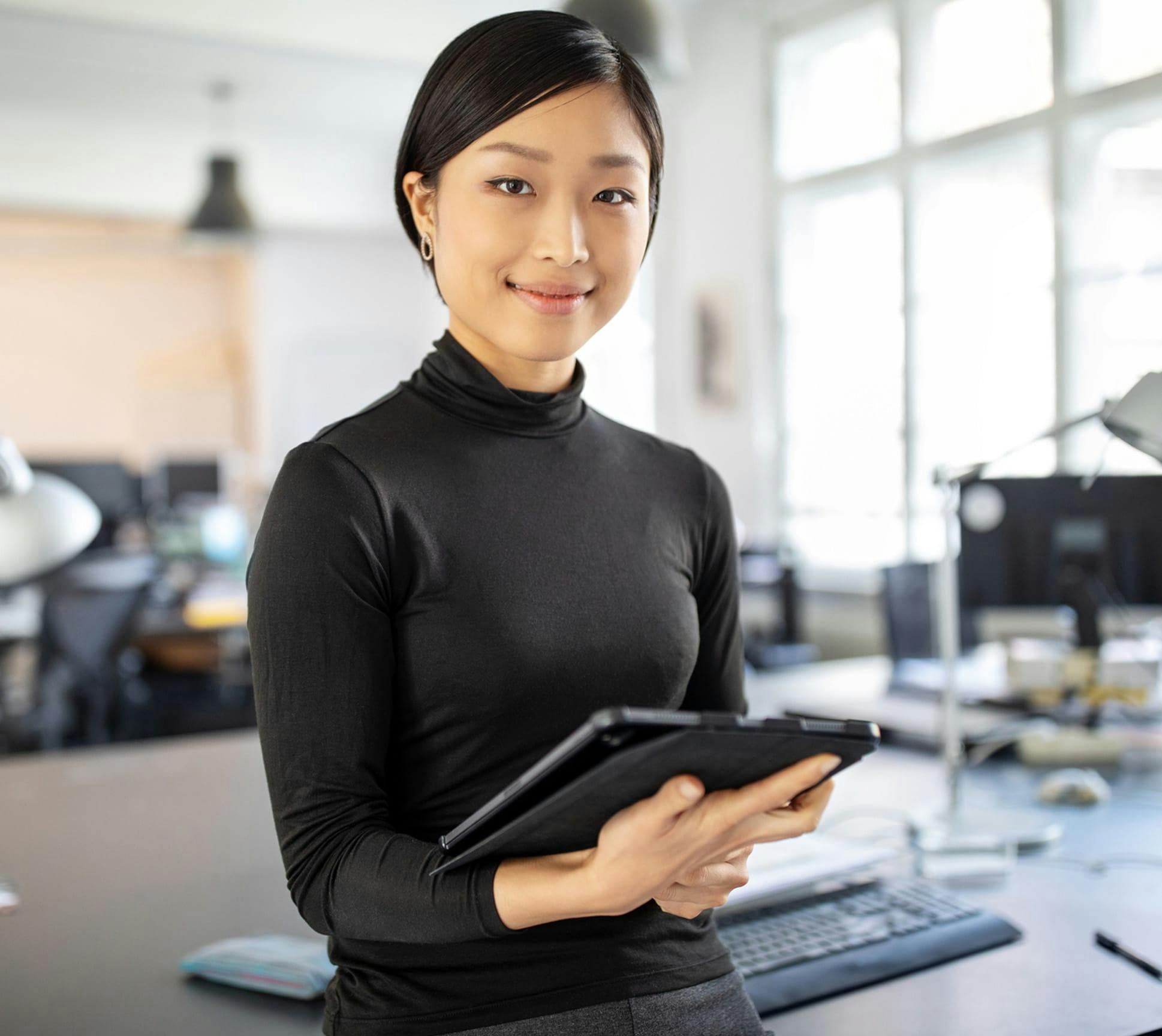 Woman in a black top holding an iPad