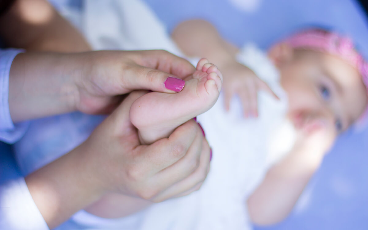 Someone playing with a baby's feet.