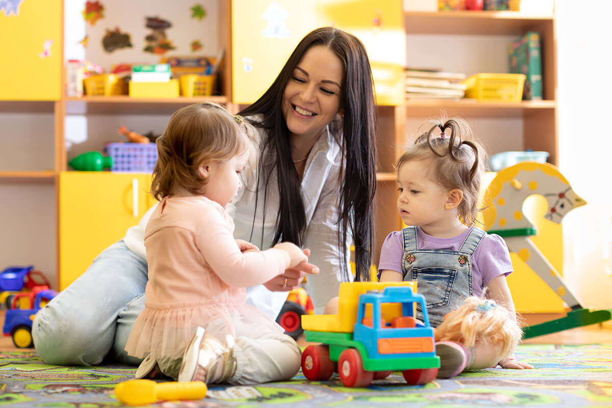 A woman playing with two little girls.