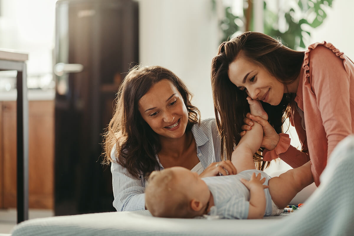 Two women doting on a baby.