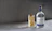 Thumbnail for front-on-shot-of-archie-rose-bone-dry-gin-on-a-concrete-surface-with-a-tall-cocktail-featuring-a-large-ginger-slice-garnish