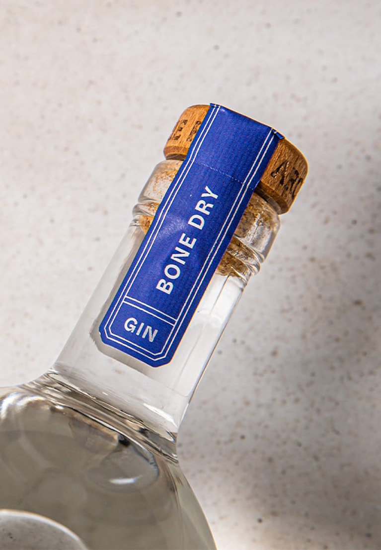 overhead-shot-of-archie-rose-bone-dry-gin-blue-bottleneck-label-reading-bone-dry-gin
