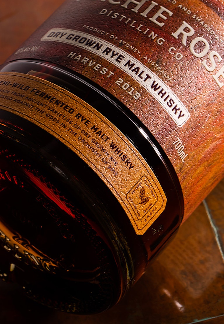 archie-rose-dry-grown-rye-malt-whisky-overhead-shot-bottom-of-bottle-and-base-label