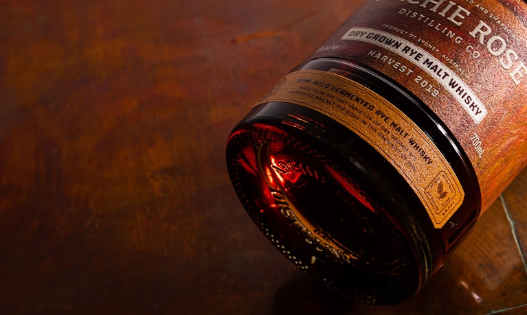 archie-rose-dry-grown-rye-malt-whisky-overhead-shot-bottom-of-bottle-and-base-label