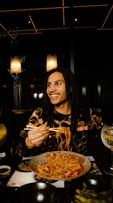 a person eating noodles