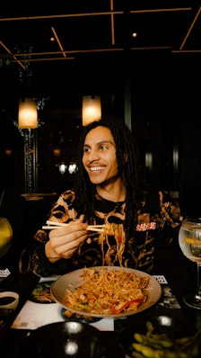 a person eating noodles