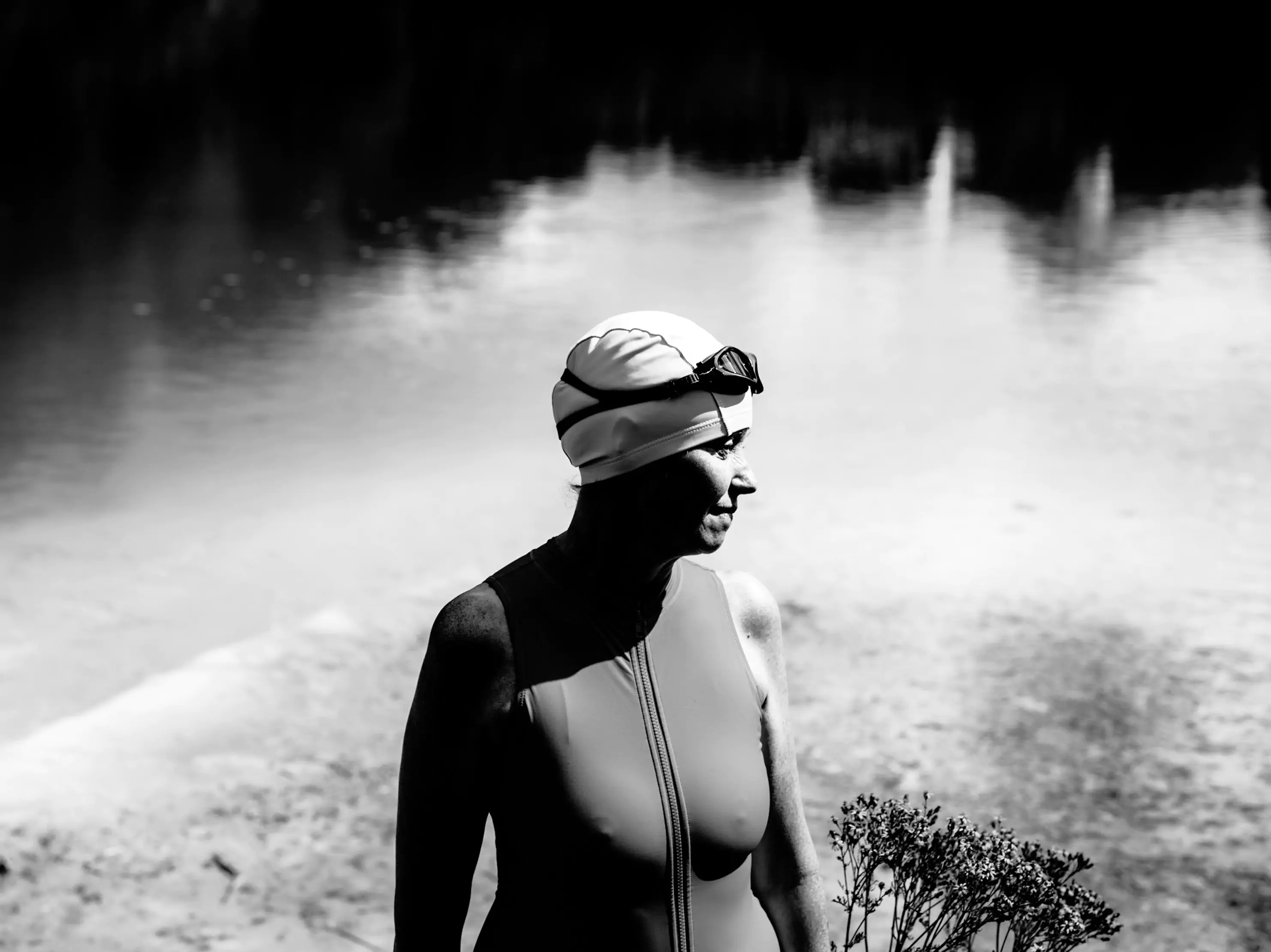 woman looking into the distance in swimsuit, swimming hat and goggles