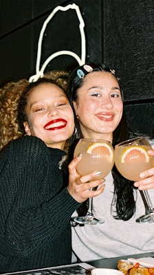 two people smiling holding cocktails