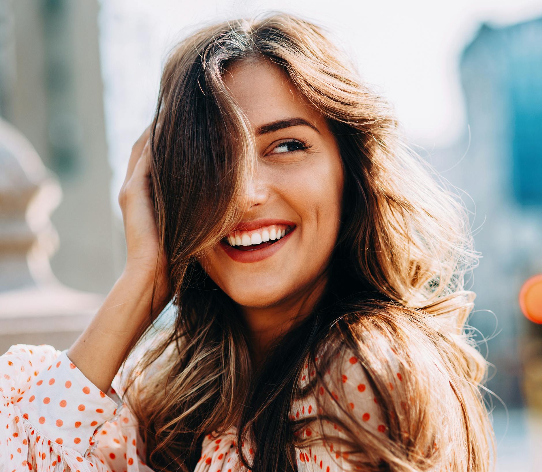 Woman wearing a polka dot blouse smiling