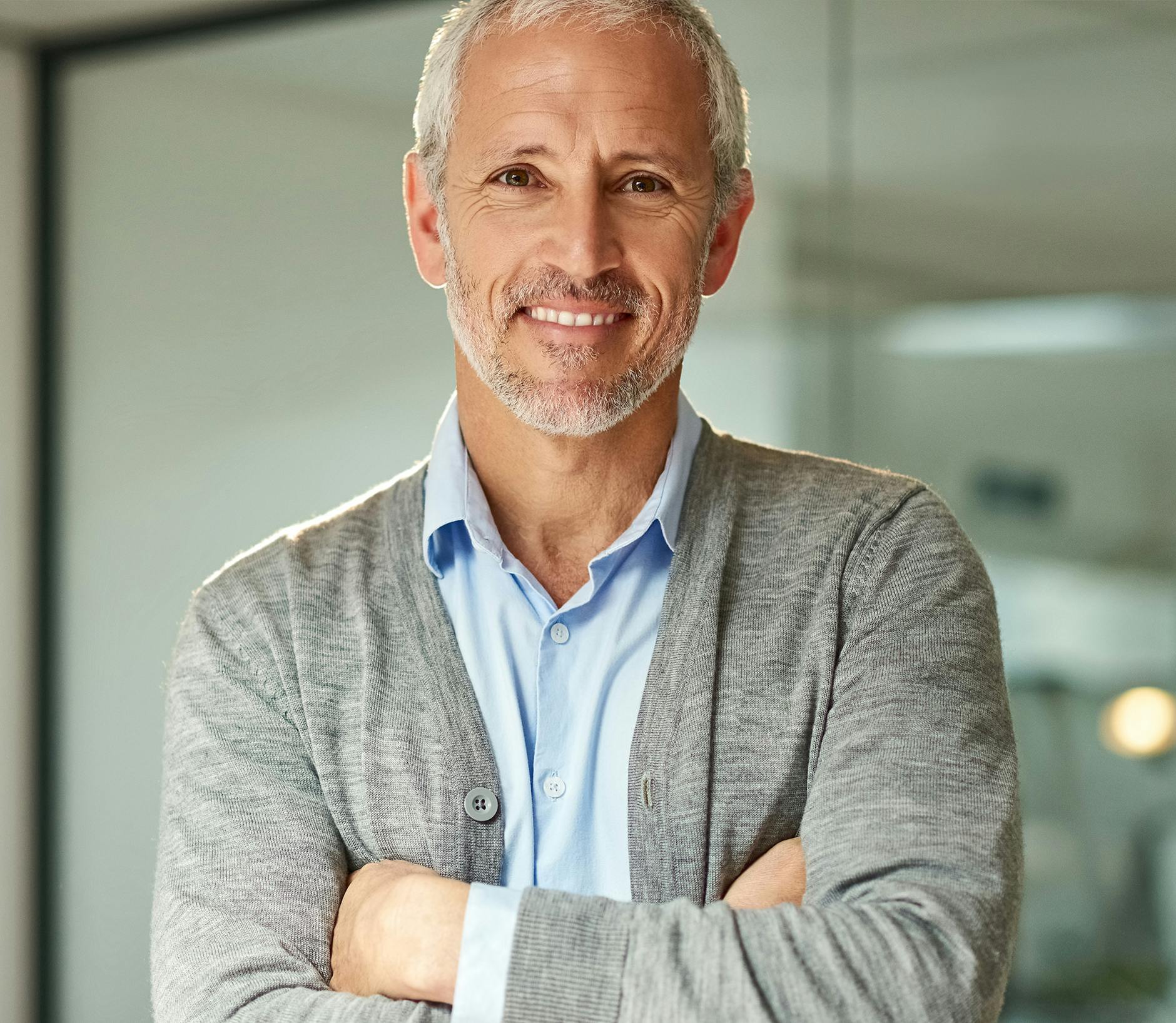 Man wearing a light blue button up and grey sweater