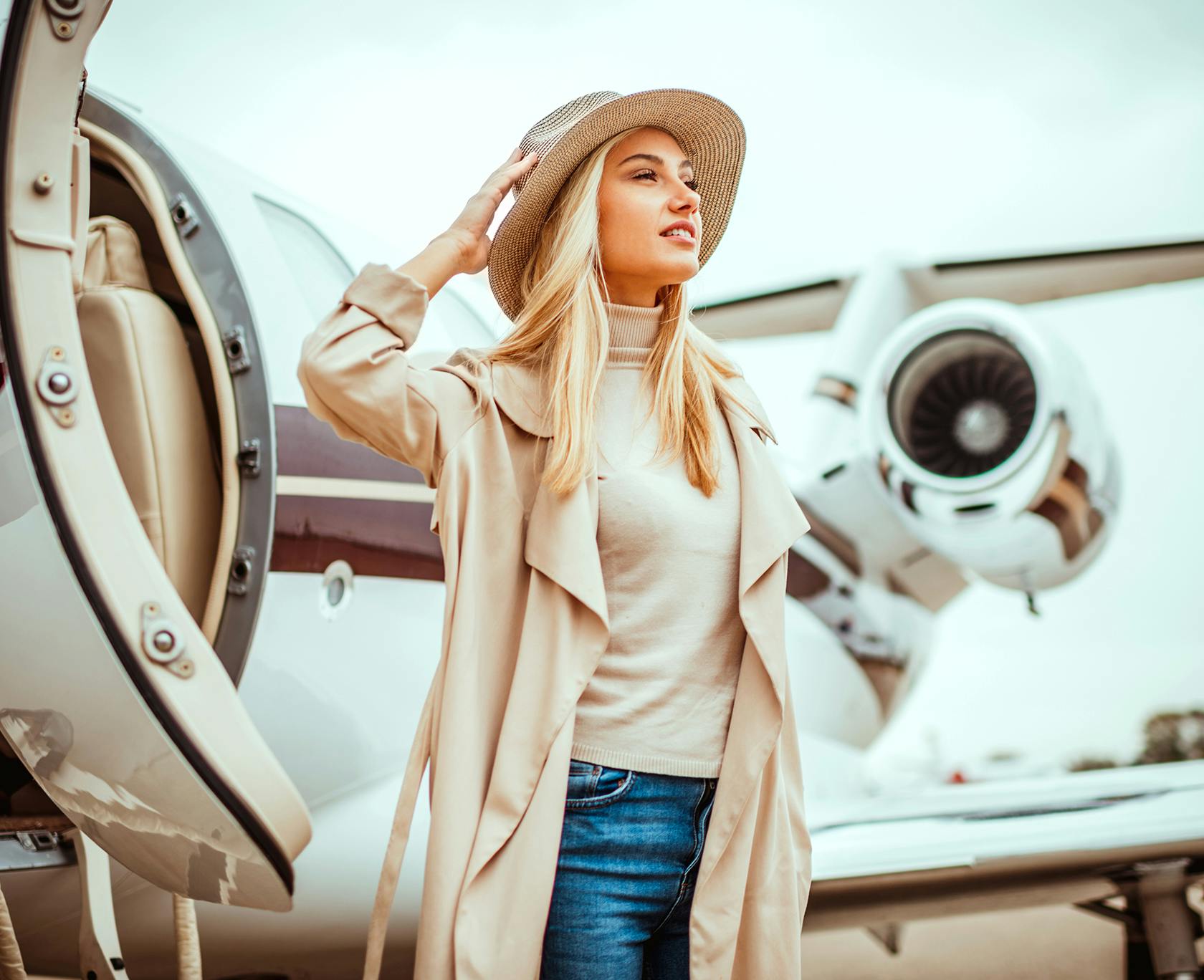 Woman in a sunhat standing outside a plane