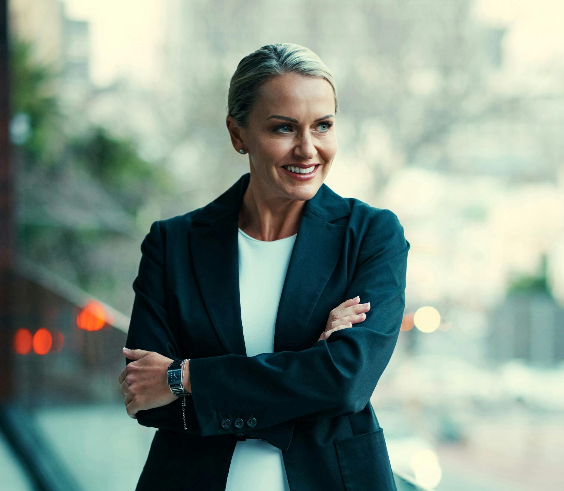 Woman in a black blazer standing on a balcony
