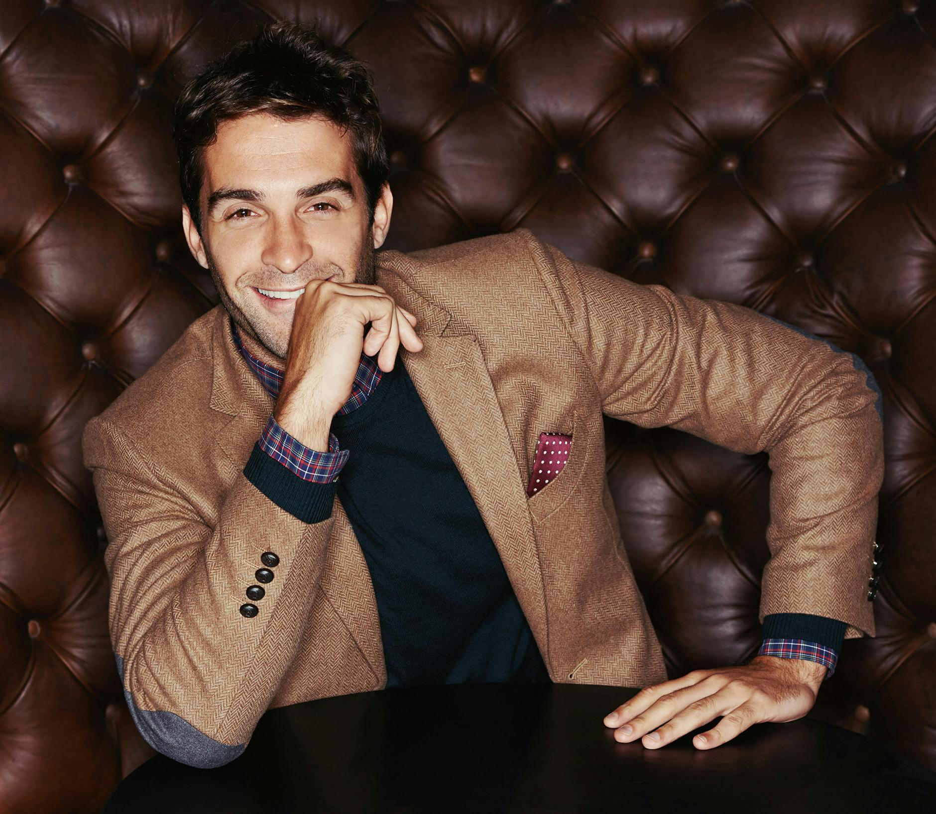 Black in brown blazer sitting down