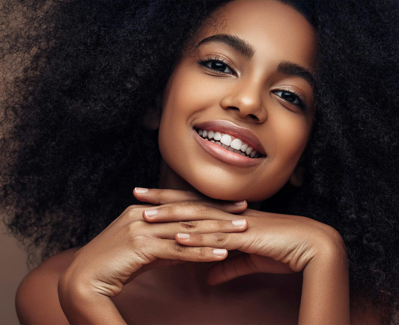 Woman with dark curly hair smiling