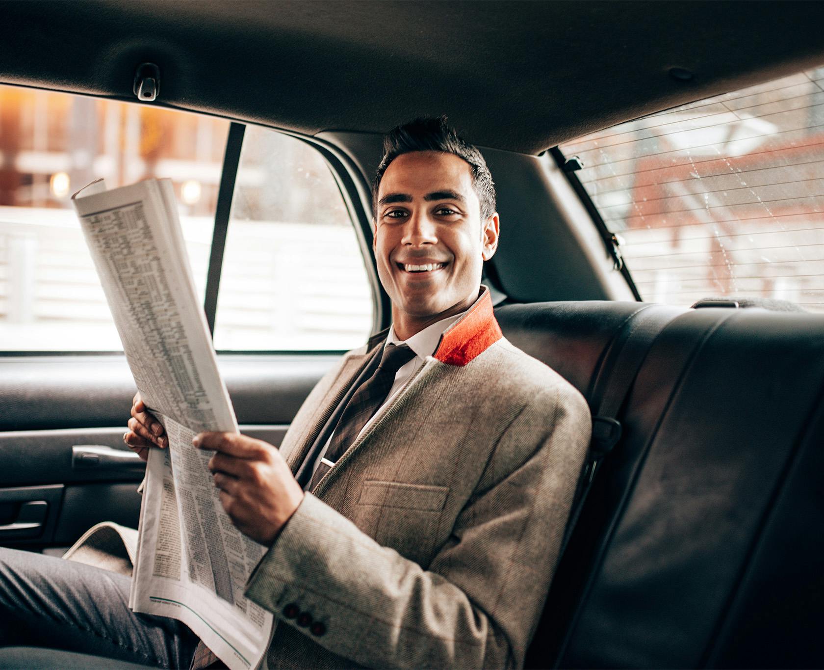 Man in formal attire sitting in a car