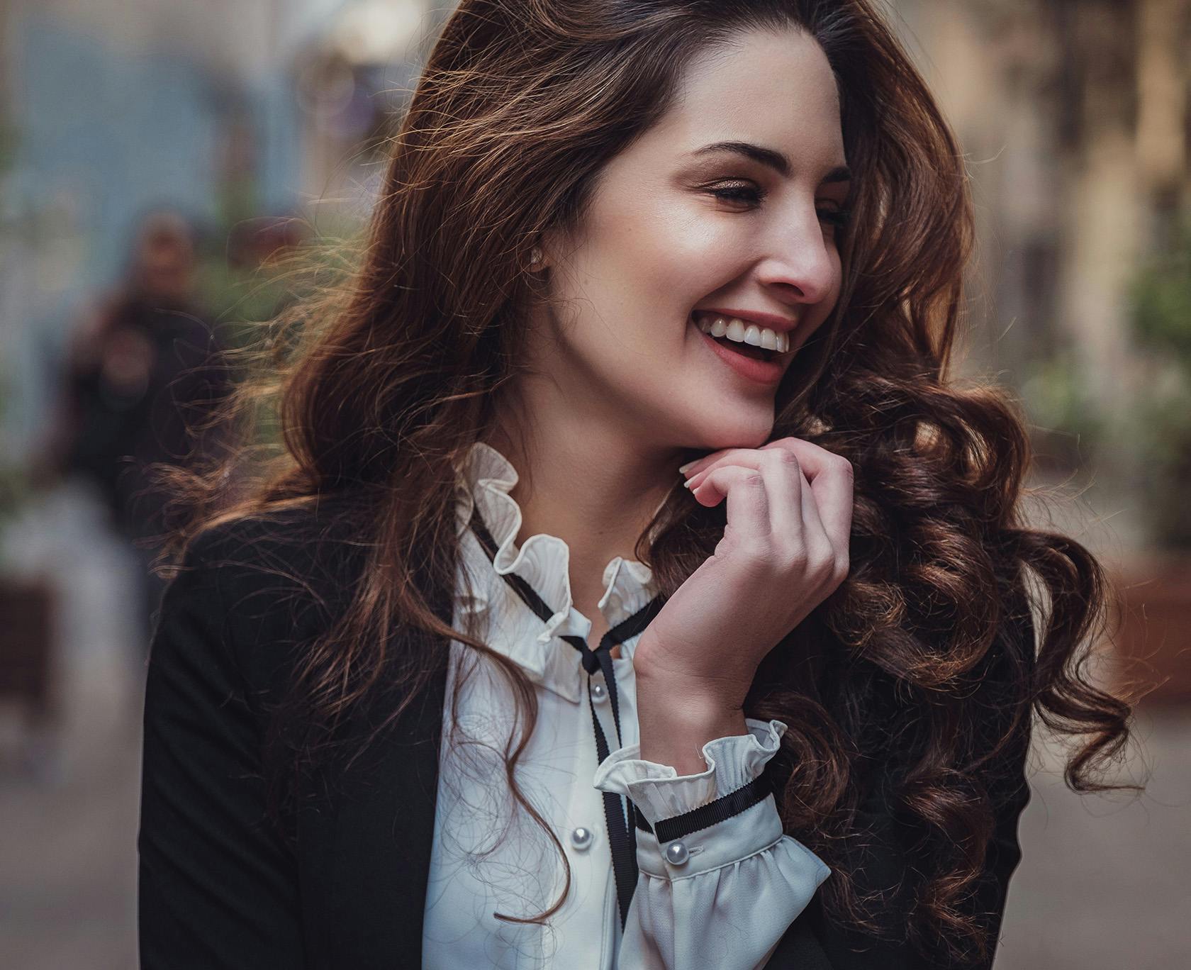 Woman in white button down and coat