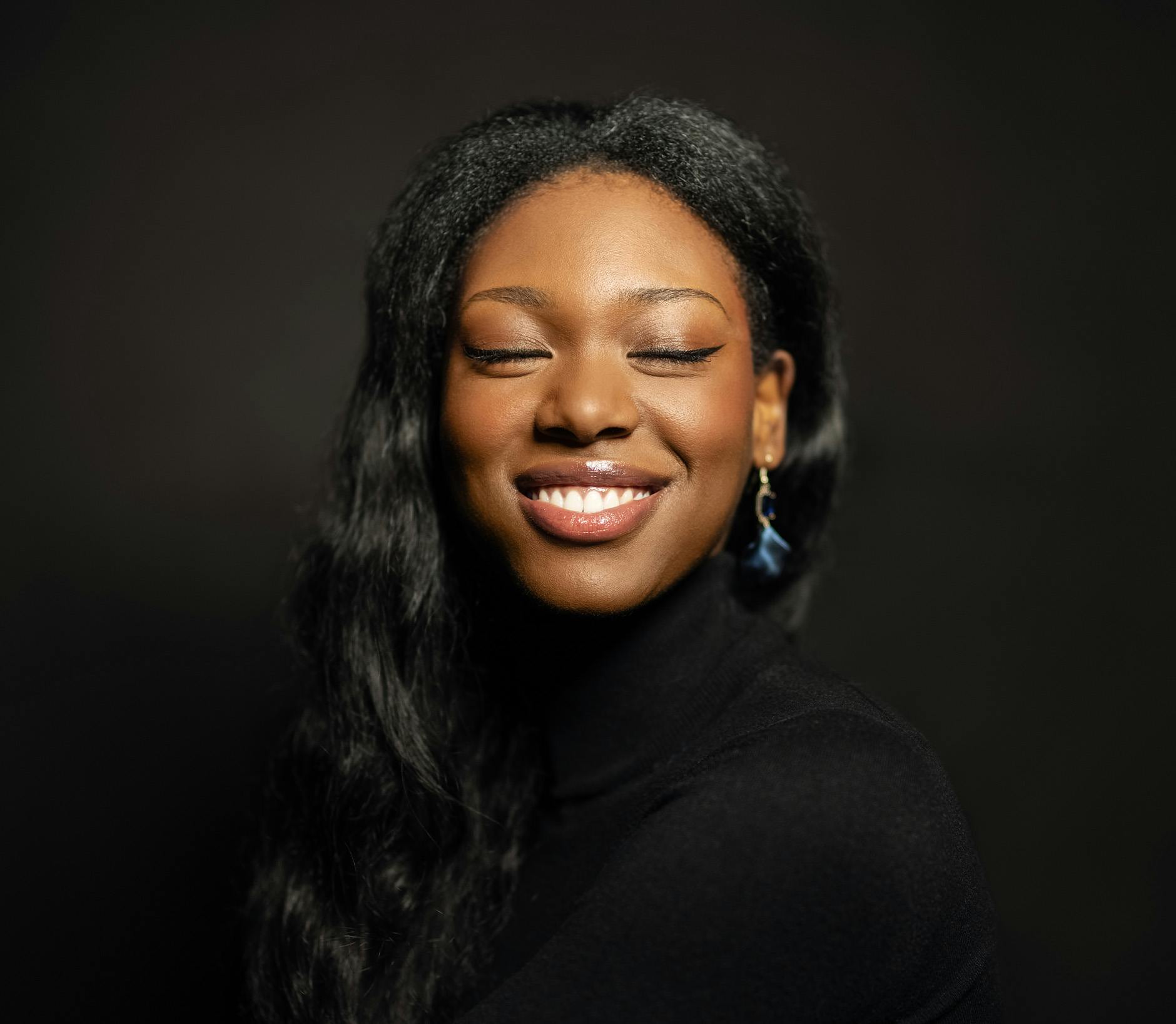 Woman wearing a black turtleneck smiling