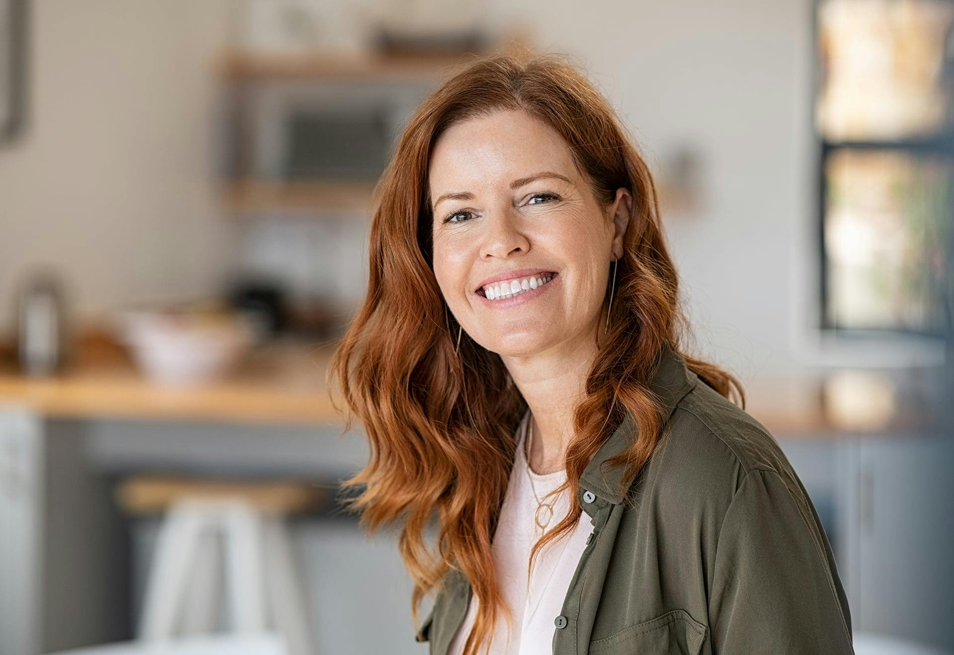 Woman sitting in her living room, smiling