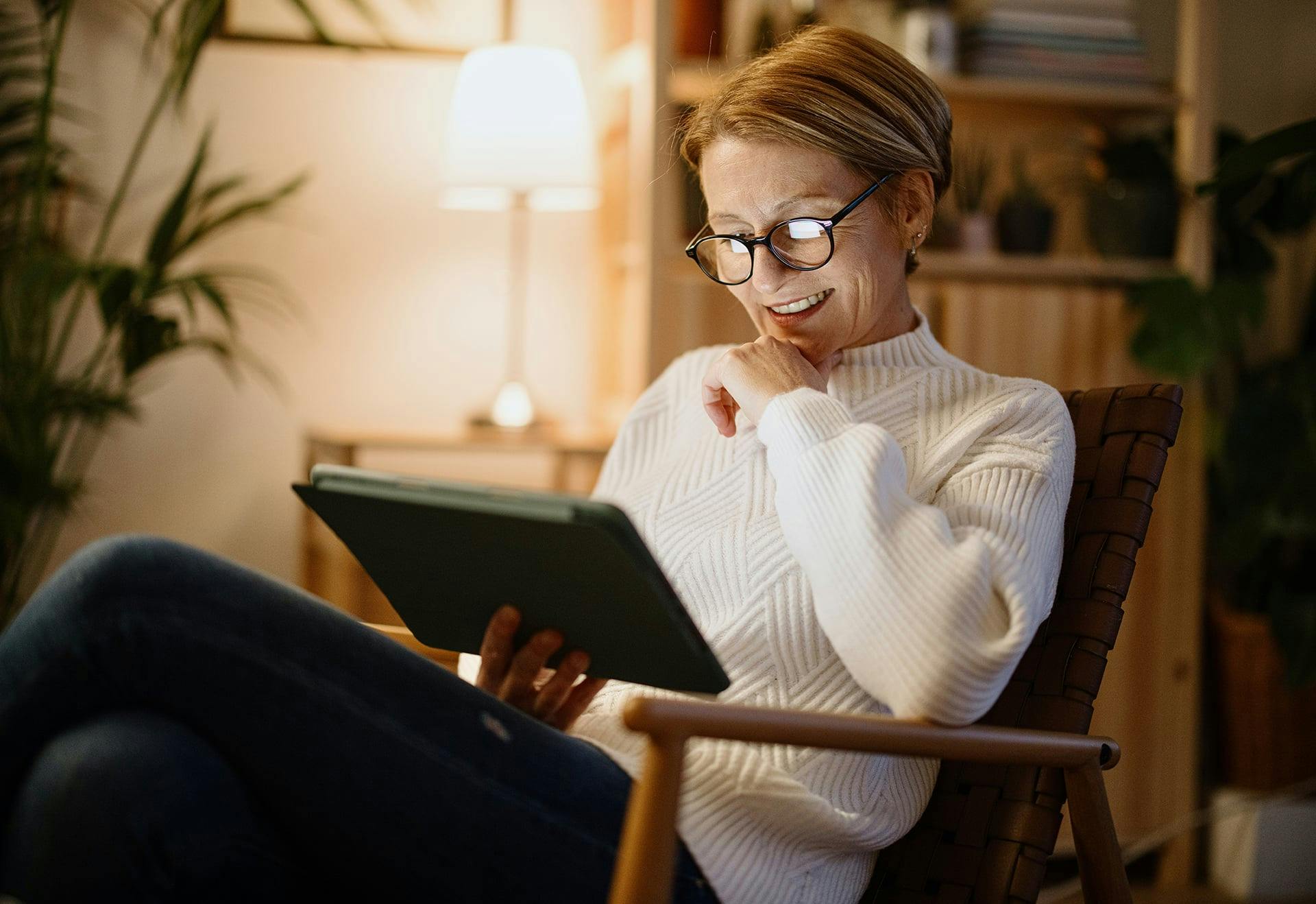 Woman sitting in a chair looking at her tablet