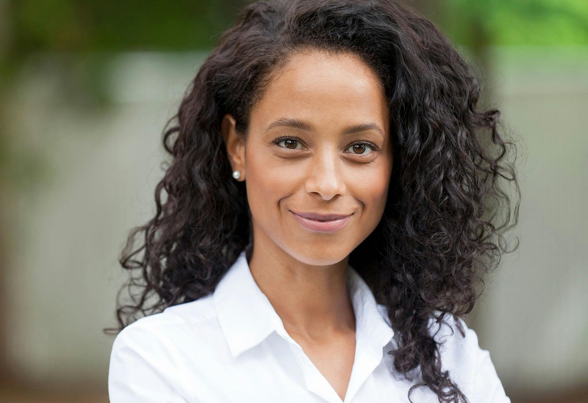 A woman with very curly hair smiling