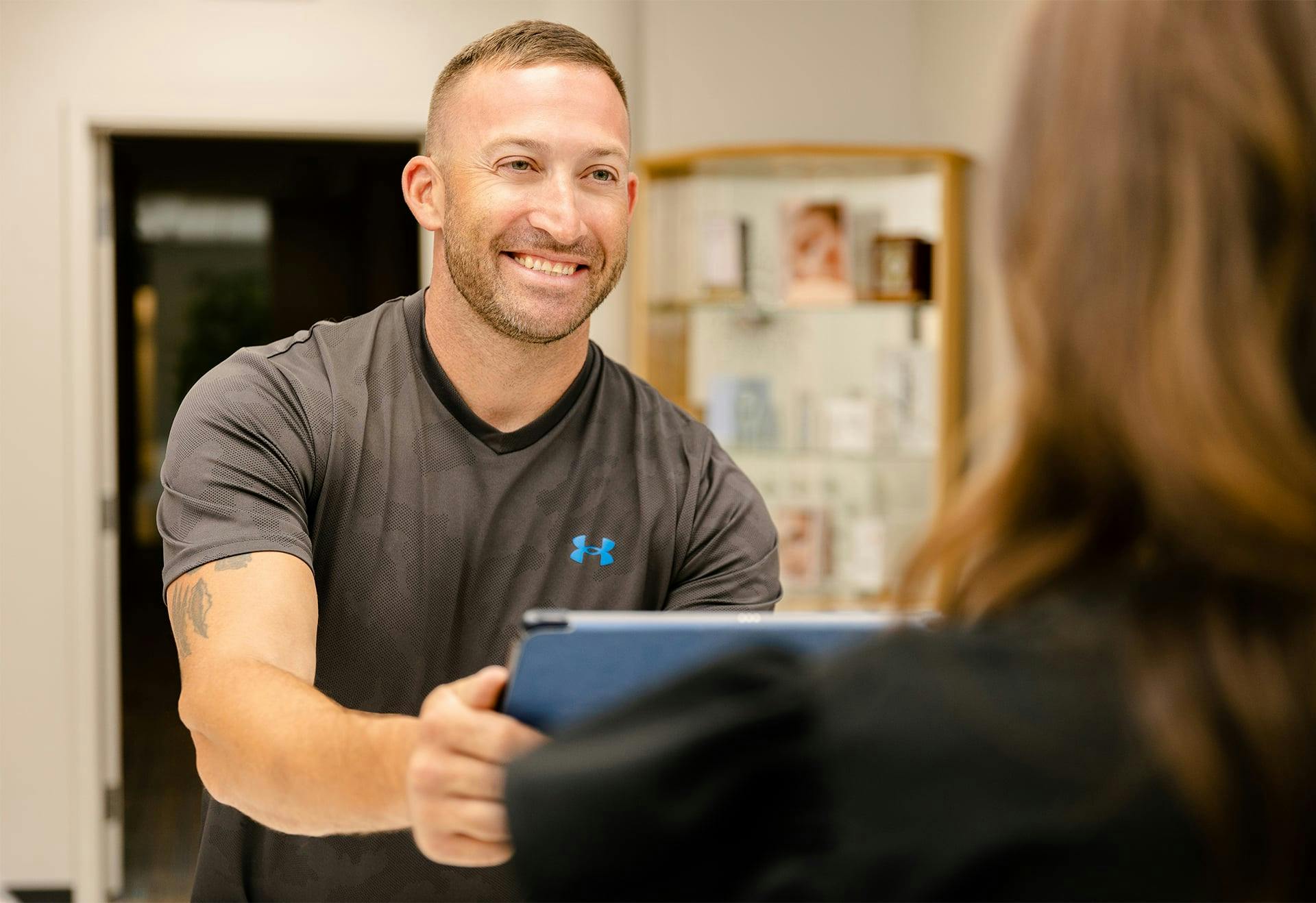 Patient giving a tablet to a staff member