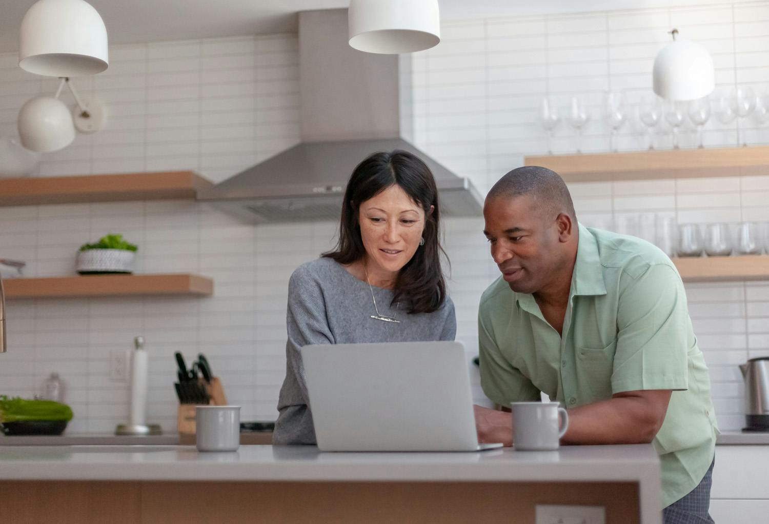 Man and woman looking at a laptop in a kitchen