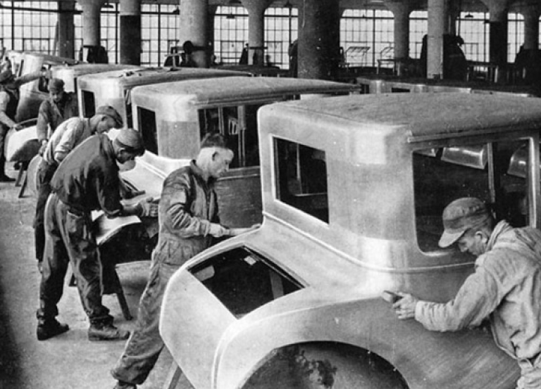 Vintage foto: Mænd, der anvender lean manufacturing på en fabrik på en bil
