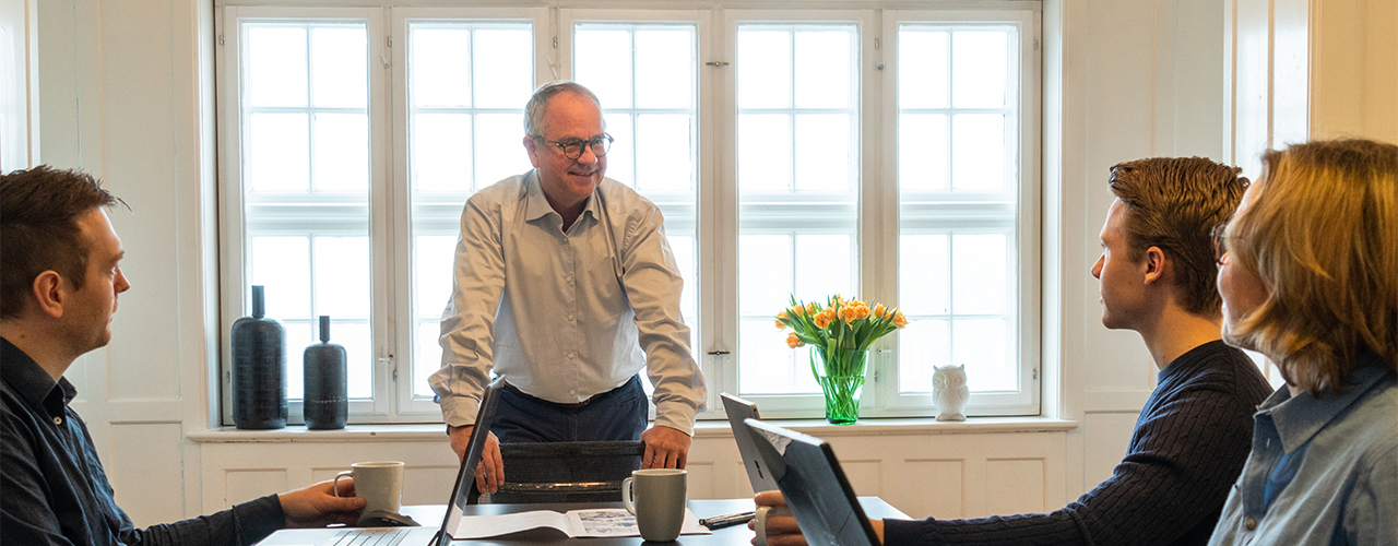 Mandlig underviser hos Compass står og kigger på sine kursister