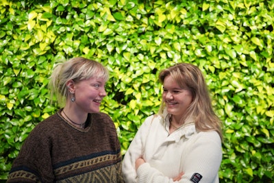 to elever står foran plantevæggen