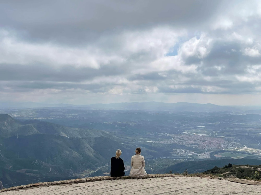 To elever med ryggen til kigger ud over en bjergtagende udsigt i Spanien