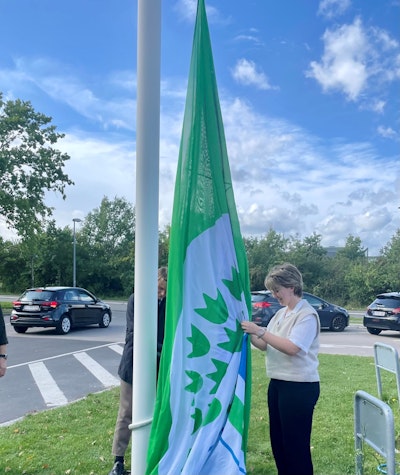 To miljørådselever hejser skolens grønne flag