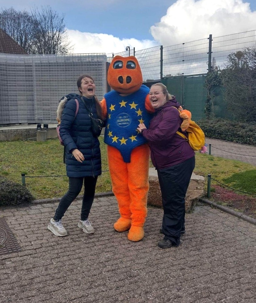 To elever står med EU-maskot i Bruxelles