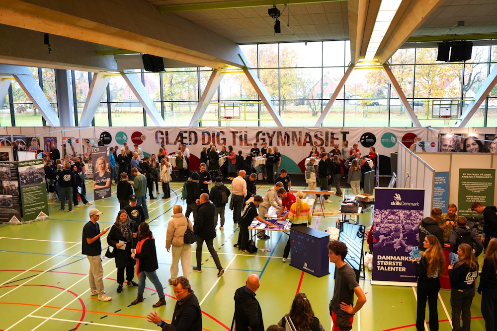 Situationsbillede af uddannelsesmesse i hallen på Roskilde Katedralskole med uddannelsesstande, unge og forældre