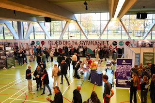 Situationsbillede af uddannelsesmesse i hallen på Roskilde Katedralskole med uddannelsesstande, unge og forældre