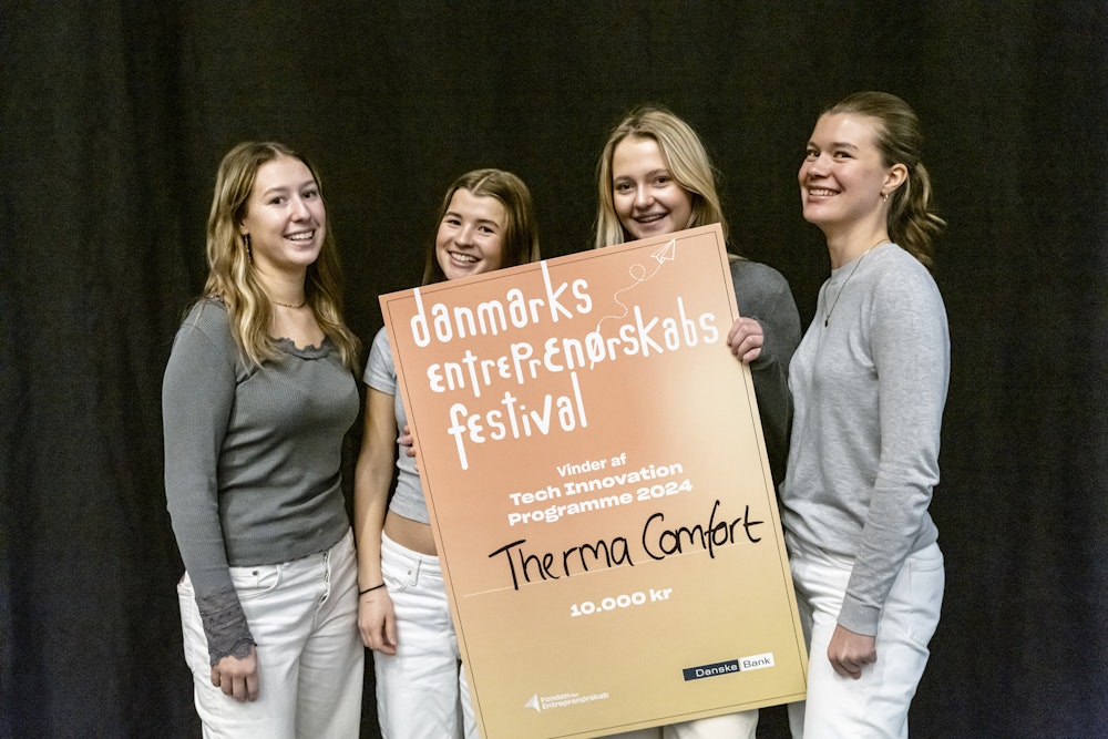 Fire smilende piger står med stort gavekort på scenen til Entreprenørskabsfestival