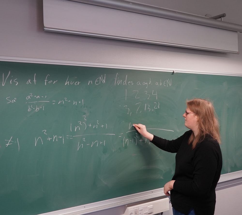 En elev står ved tavlen og løser en matematikopgave