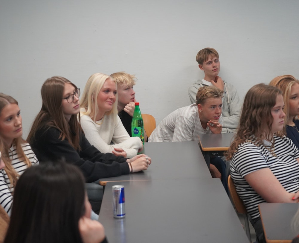 Elever sidder i et klasseværelse og lytter koncentreret