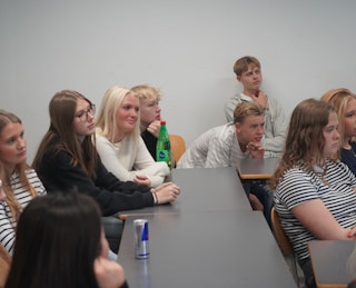 Elever sidder i et klasseværelse og lytter koncentreret