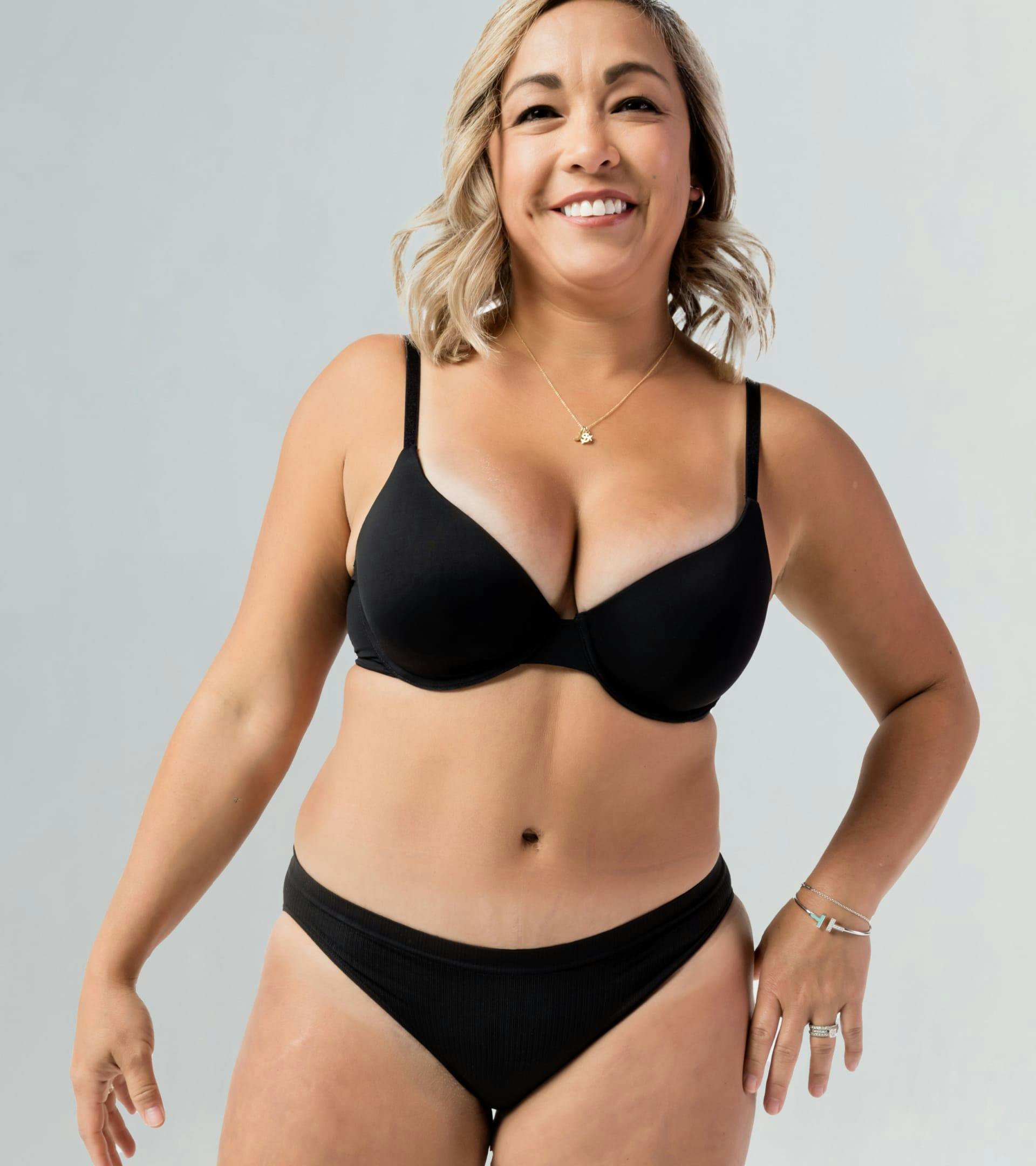 Smiling woman in black bra and panties.