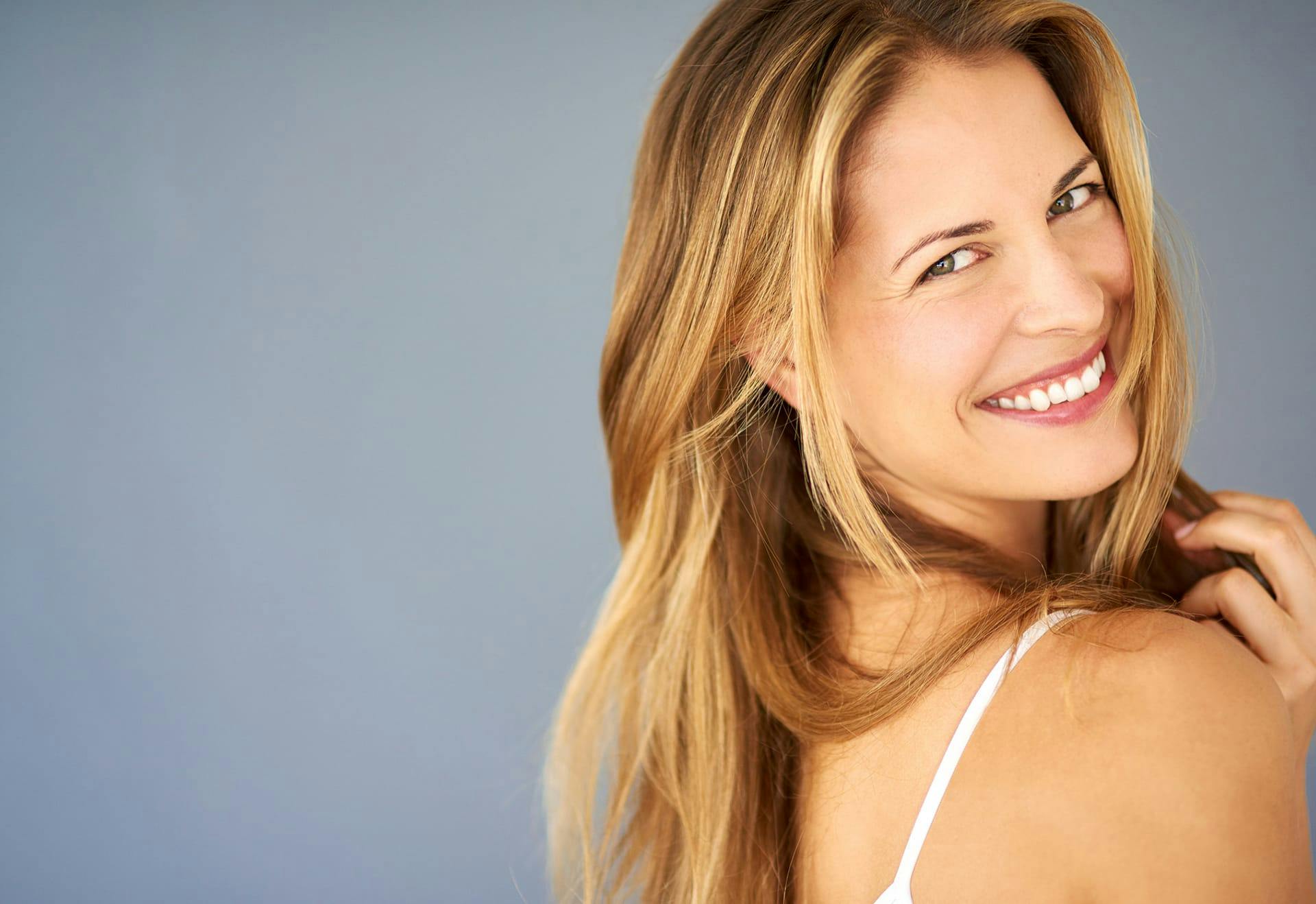 Woman smiling while looking over her shoulder
