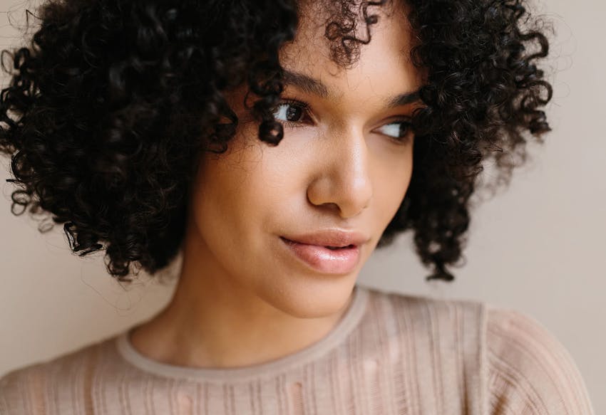 Woman with curly hair looking to the side