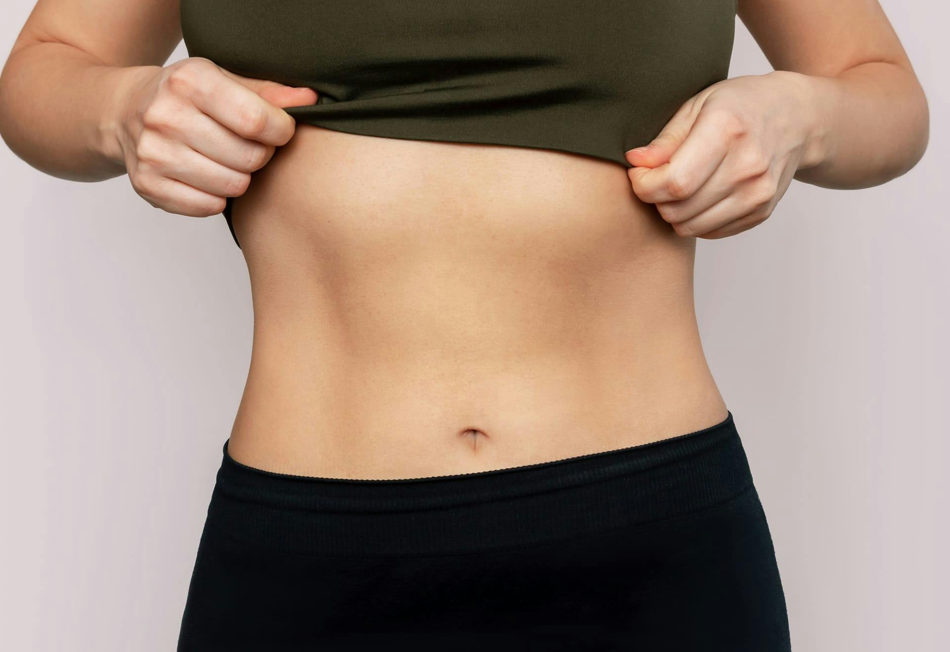Woman lifting her shirt up to show her stomach