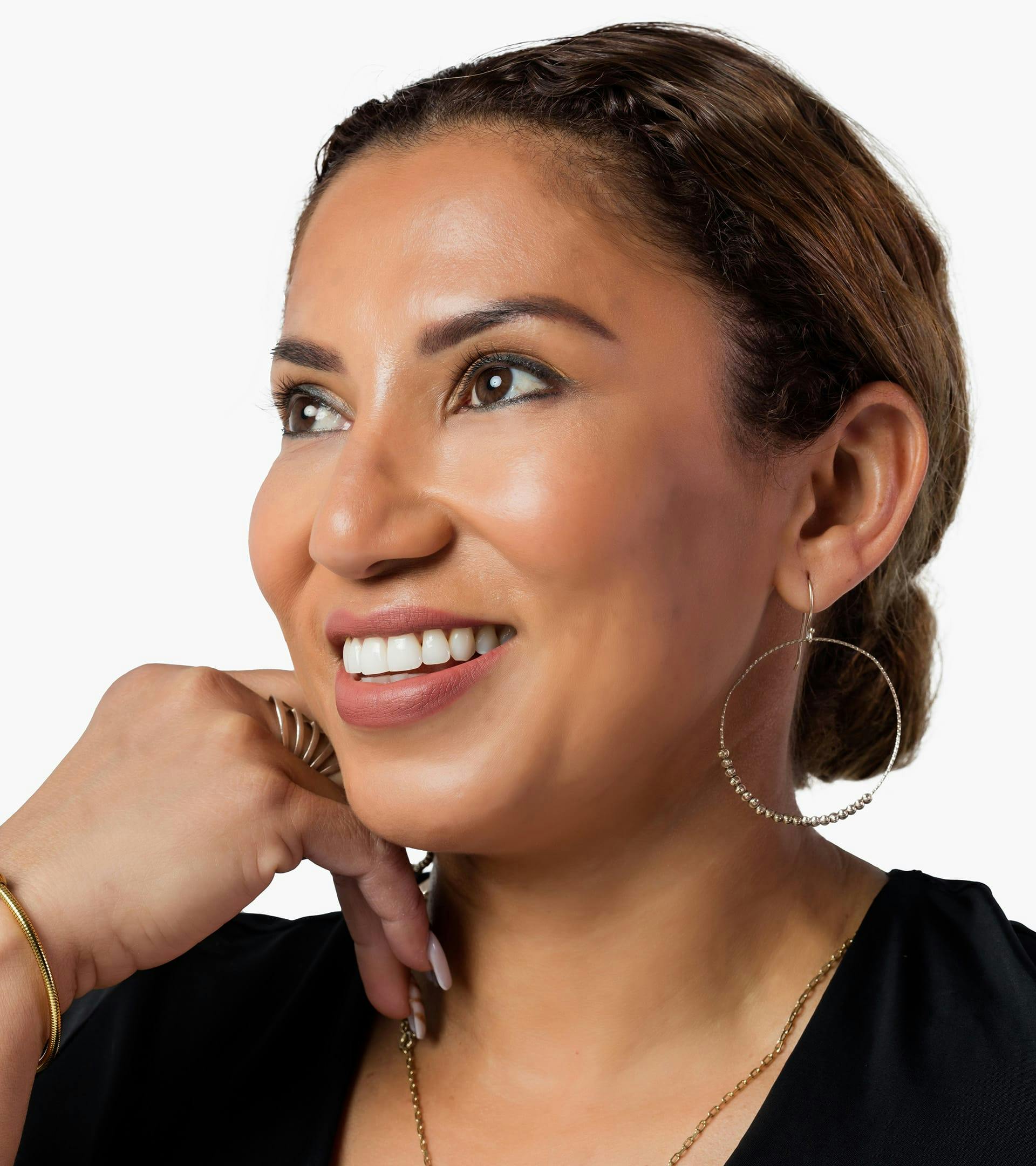 close up of a woman's face with a black shirt and gold hoop earrings